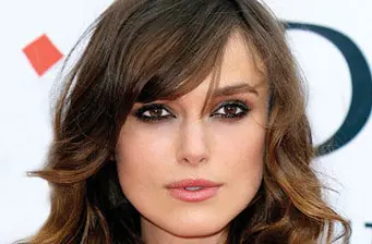 Close-up headshot of Keira Knightley with brown hair and makeup