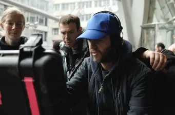 Three people reviewing video footage on set with monitor