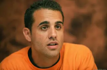 Bobby Cannavale headshot in orange shirt looking off-camera