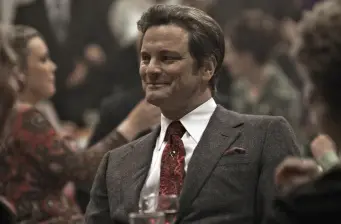 Man in grey suit with red tie smiling at event