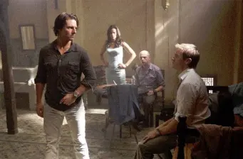 Four people in tense conversation in dimly lit room from Mission: Impossible