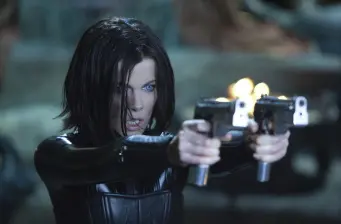 woman with black hair aiming two pistols aggressively