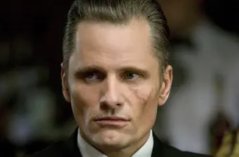 close-up of man with serious expression and scar on cheek