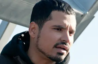 Michael Peña close-up looking serious in outdoor setting