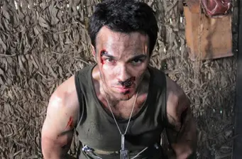 Shalim Ortiz with bloody face and tank top, intense movie scene