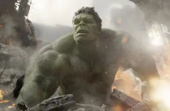 The Hulk in battle with damaged rubble and fire around him