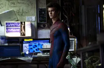 Spider-Man in full costume stands inside a lab with screens behind him