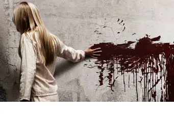 Girl in pajamas touches bloody handprint on wall in horror poster