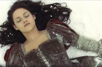 woman wearing dark dress lying in snow with eyes closed