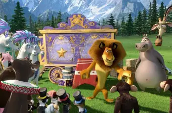 Animated animals, including a lion and hippo, near circus wagon outdoors