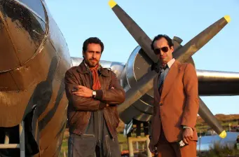 Demián Bichir and another man by airplane propeller outdoors
