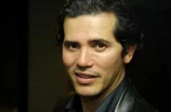 Headshot of Colombian-American actor John Leguizamo smiling slightly