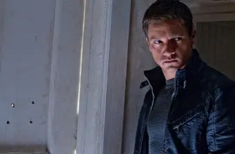 Jeremy Renner in dark jacket looks right in tense movie still