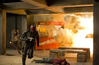 Man in tactical armor flees explosion in intense action scene