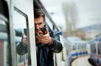 Liam Neeson aims gun from vehicle in Taken 2 action scene