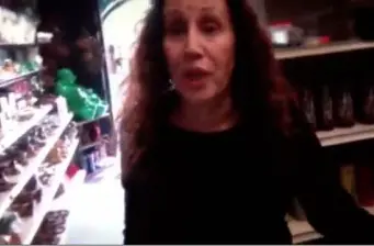 woman with long curly hair standing inside store aisle