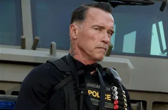 Arnold Schwarzenegger in police gear on movie set