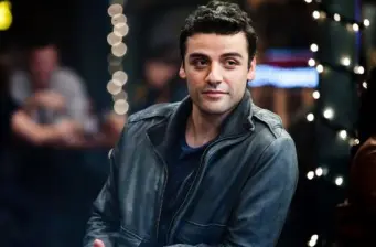 Oscar Isaac in leather jacket looking sideways in casual setting