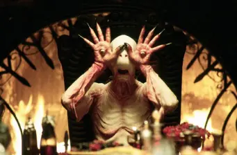 Faun creature from Pan's Labyrinth holds hands near face