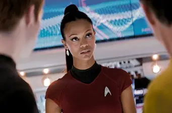 Uhura in red uniform listens on starship bridge in Star Trek Into Darkness