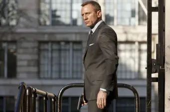 Daniel Craig in suit holding gun outside in Skyfall scene