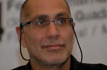 Headshot of Guillermo Arriaga wearing glasses, looking off camera