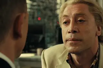 Javier Bardem close-up shot looking at another man in suit