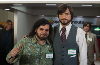 Two men posing in office, one in patterned shirt, one in vest and tie