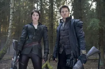 two armed characters in dark leather outfits stand in forest