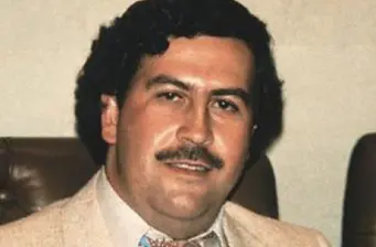 Headshot of Pablo Escobar wearing beige jacket and white shirt