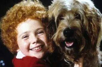 Young smiling red-haired child with large fluffy dog