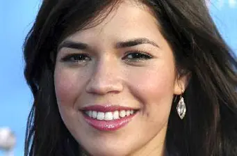 Close-up headshot of America Ferrera smiling with earrings