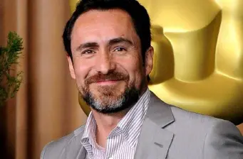 Demián Bichir smiling headshot with Oscar statue behind him