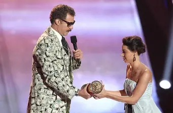 Aubrey Plaza accepts award from man in patterned suit on stage