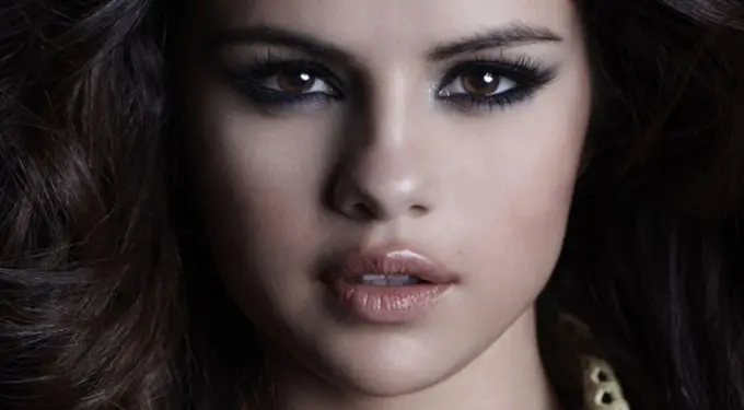 Close-up headshot of Selena Gomez with smoky eye makeup and loose hair