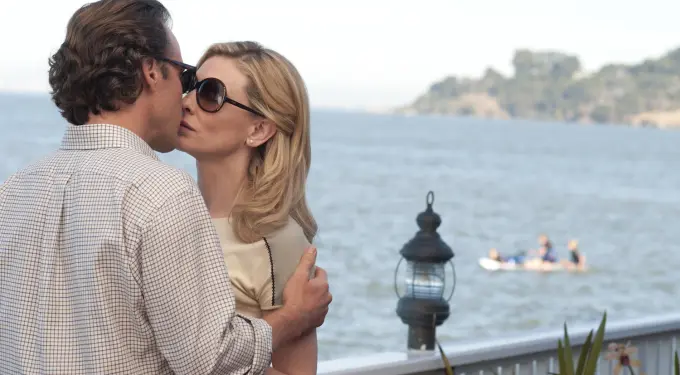 Man and woman wear sunglasses sharing intimate moment by waterfront