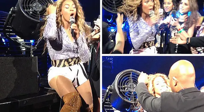 Beyoncé singing on stage reacting as a fan pulls her hair