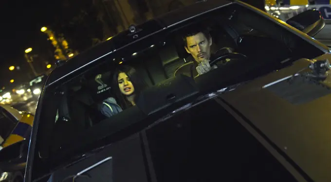 Selena Gomez and male driver inside car at night, tense expressions