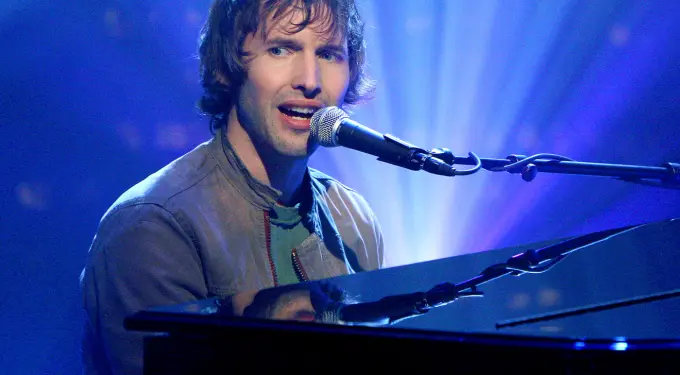 James Blunt singing and playing piano during concert performance
