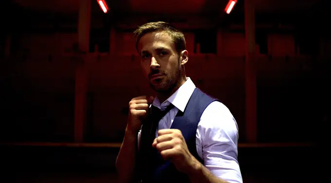 Ryan Gosling in fighting stance under dark red lighting in movie scene