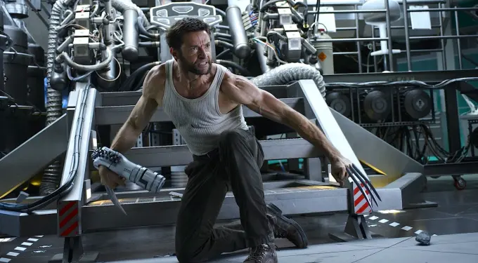 Hugh Jackman as Wolverine crouching with claws and robotic arm