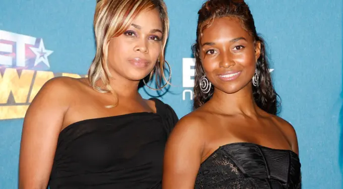 Two women from TLC duo pose at BET Awards backdrop