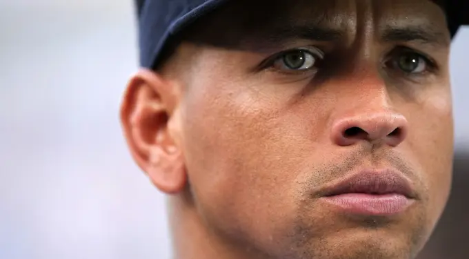 Close-up headshot of Alex Rodriguez wearing a cap, looking serious