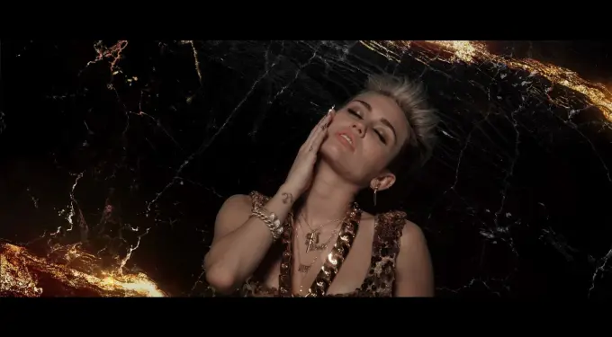 Miley Cyrus with closed eyes and hand on face, dark marble background