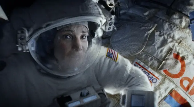 astronaut in space suit floating near spacecraft with USA patch