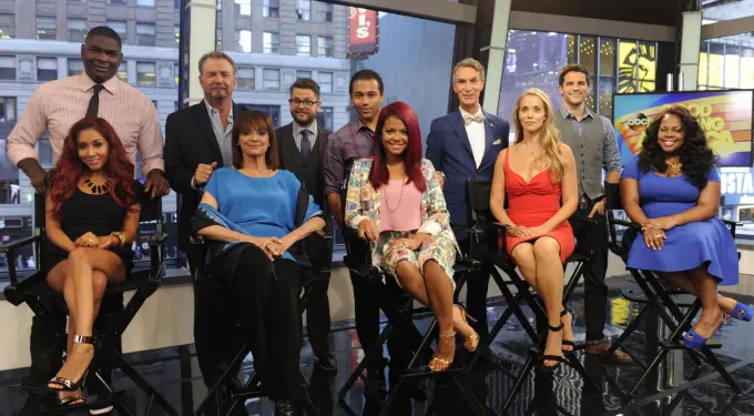 Dancing With The Stars cast posing together inside studio with city view