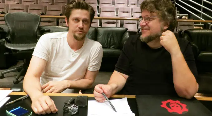 Andrés Muschietti and Guillermo del Toro seated at table with papers