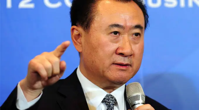 Wang Jianlin speaking into microphone and pointing finger