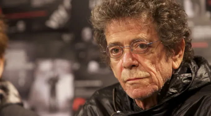 Close-up of Lou Reed wearing glasses and a black jacket