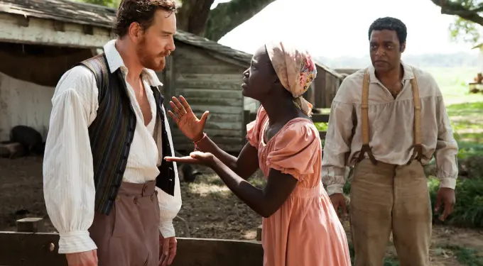 Three actors in period costumes with woman speaking urgently to man